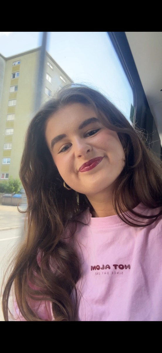 Lisa, Gründerin von NOT ALONE, in einem rosé NOT ALONE Shirt